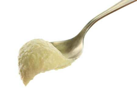 Spoon with delicious hummus isolated on whiteの写真素材