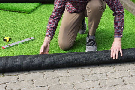 Man installing artificial turf outdoors, closeup viewの写真素材