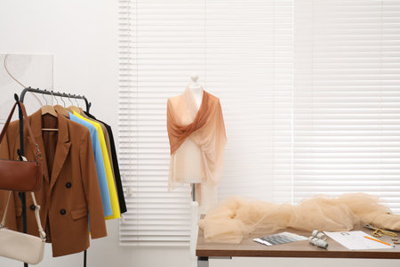 Fashion designer`s workplace with fashionable clothes, fabric samples and sewing suppliesの写真素材
