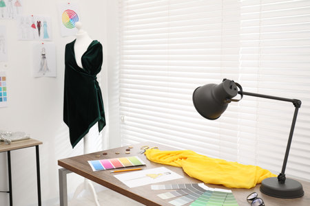 Fashion designer`s workplace with color palette, fabric samples and sewing suppliesの写真素材