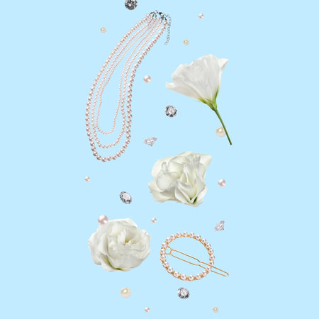 Gemstones, jewelry, pearls and flowers in air on light blue backgroundの写真素材