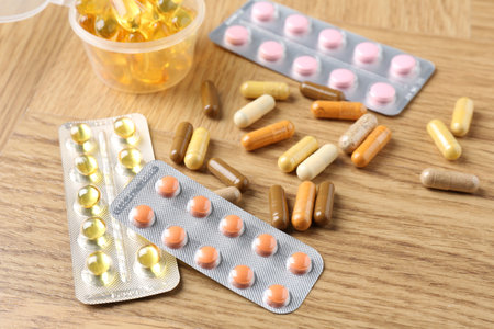 Pharmacist. Different pills on wooden table, closeup