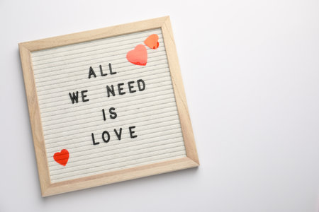 Letter board with phrase All We Need Is Love and decorative heart on white background, top view. Space for textの写真素材