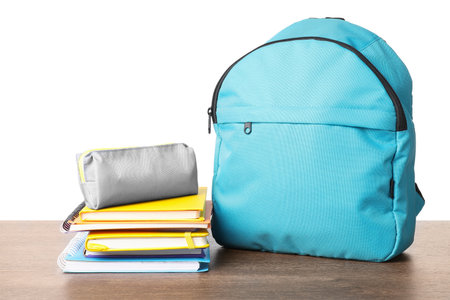 Backpack with different school stationery on wooden table against white backgroundの写真素材