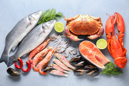 Many different sea food on gray textured table, flat layの写真素材