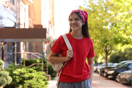 Smiling teenage girl walking on city streetの写真素材