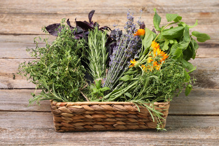 Different aromatic herbs in basket on wooden tableの写真素材