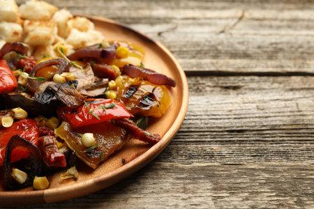 Delicious salad with grilled vegetables on wooden table, closeup. Space for textの写真素材