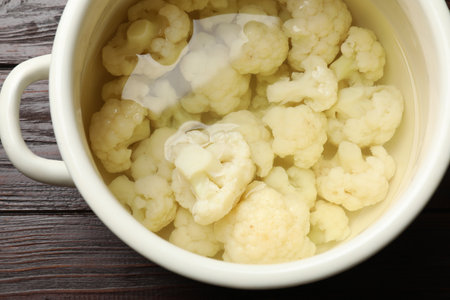 Cauliflower in pot with water on wooden table, closeupの写真素材