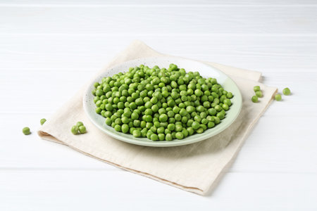 Fresh green peas on white wooden tableの写真素材