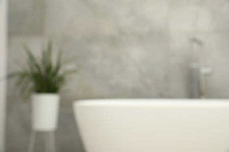 Blurred view of bath tub and houseplant in bathroomの写真素材