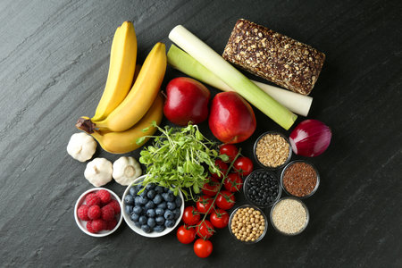Different fresh products on black table, flat lay. Source of prebioticsの写真素材