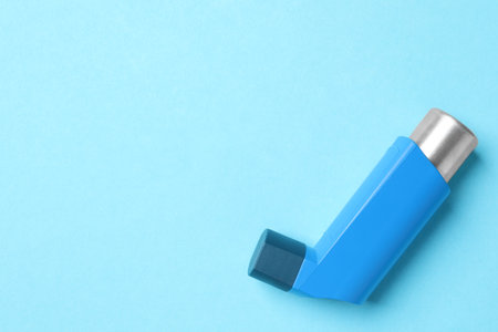 Asthma inhaler on light blue background, top view. Space for textの写真素材