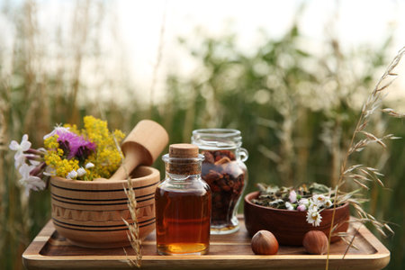 Tincture in bottle, different ingredients, mortar and pestle outdoorsの写真素材