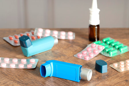 Different asthma medications on wooden table indoors, closeupの写真素材