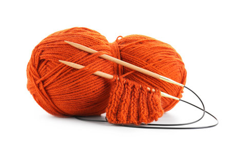 Skein of orange yarn, knitted fabric and needles isolated on whiteの写真素材