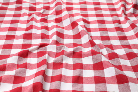 Crumpled checkered tablecloth as background, closeup view