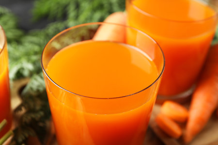 Healthy carrot juice in glasses and fresh vegetable on table, closeupの写真素材