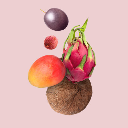 Coconut, dragonfruit, mango, lychee and maracuja in air on pink background. Tropical fruits