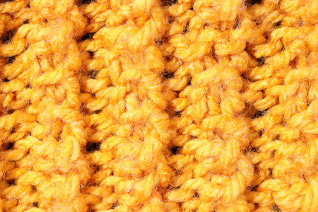 Texture of yellow knitted fabric as background, top view