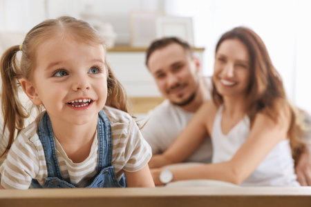 Happy family. Parents and their cute little daughter on sofa at home, selective focusの写真素材