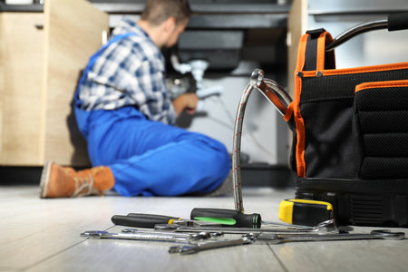 Professional plumber fixing piping system at home, focus on toolsの写真素材