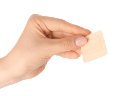 Woman holding medical adhesive bandage on white background, closeupの写真素材