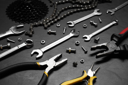 Different bicycle components and tools on dark gray textured background, closeupの写真素材