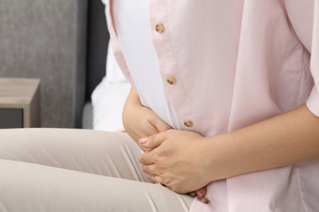 Woman suffering from menstrual pain at home, closeupの写真素材