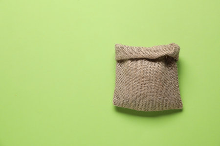 One burlap sack on light green background, top view. Space for textの写真素材