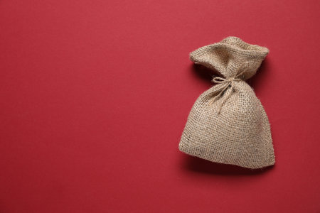One burlap sack on red background, top view. Space for textの写真素材