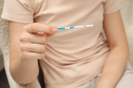 Woman holding negative pregnancy test indoors, closeup viewの写真素材