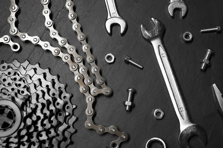 Different bicycle components and tools on dark gray textured background, flat layの写真素材