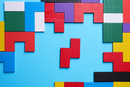 Colorful wooden puzzle pieces on light blue background, top viewの写真素材