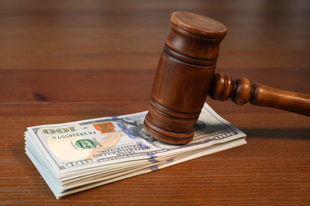 Alimony. Judge's gavel and stack of money on wooden table, closeupの写真素材