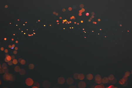 Beautiful shiny golden glitter on black background, closeup