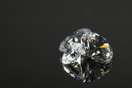 Beautiful shiny diamonds on black mirror surface, closeup. Space for textの写真素材