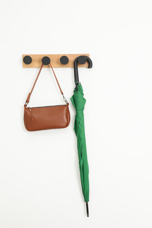 Green umbrella and bag on rack in hallwayの写真素材