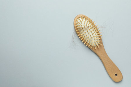 One brush with lost hair on gray background, top view. Space for textの写真素材
