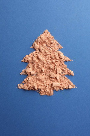 Christmas tree made with face powder on blue background, top viewの写真素材