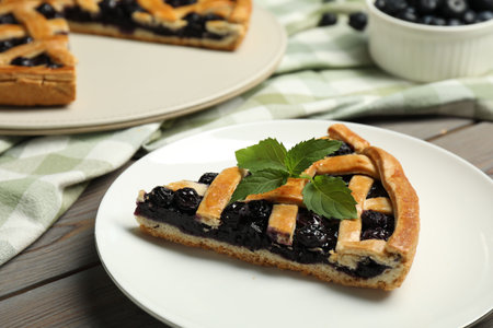 Piece of tasty homemade pie with blueberries and mint on table, closeupの写真素材