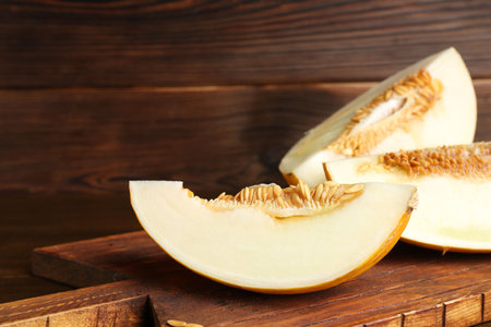 Cut fresh ripe melon on wooden table, space for textの写真素材