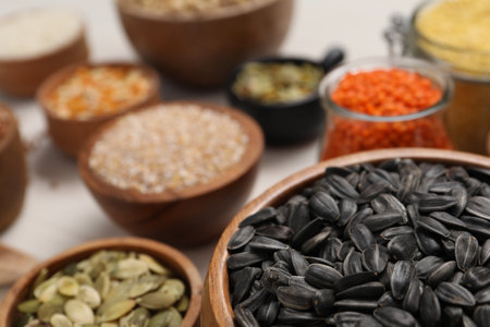 Different types of seeds, cereals and legumes on white table, closeupの写真素材