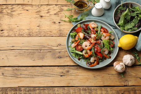 Delicious shrimp salad with ingredients on wooden table, flat lay. Space for textの写真素材