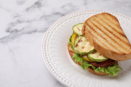 Tasty sandwich with grilled vegetables on white marble table, closeup. Space for textの写真素材