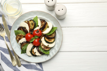 Tasty salad with grilled vegetables and mozzarella cheese served on white wooden table, flat lay. Space for textの写真素材