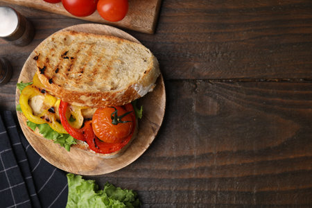Tasty sandwich with grilled vegetables on wooden table, flat lay. Space for textの写真素材