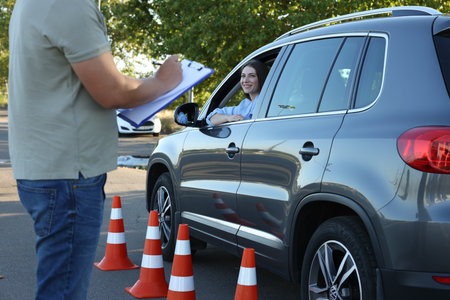 Examiner with clipboard during exam at driving school test track, closeupの写真素材