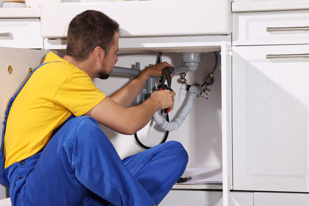 Professional plumber fixing piping system at homeの写真素材