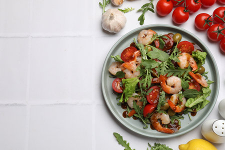 Delicious shrimp salad with ingredients on white tiled table, flat lay. Space for textの写真素材